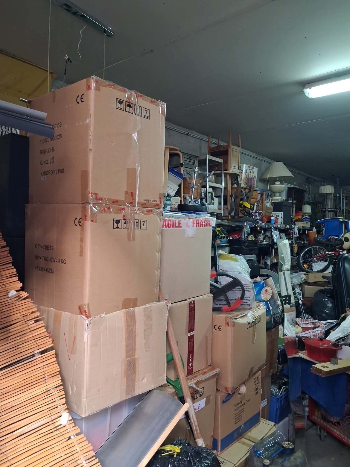 Local très encombré avec cartons, avant intervention